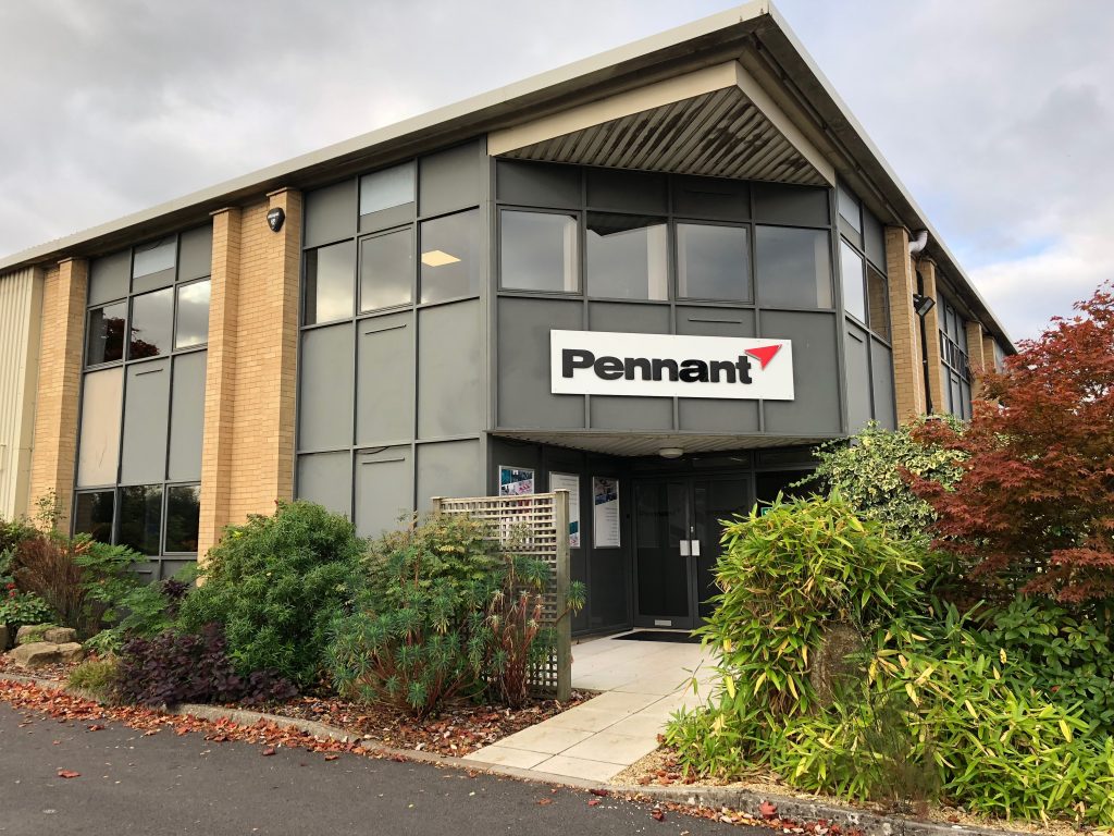 An image of a large office building with the word "Pennant" on it in black letters