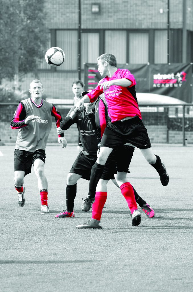 Three people playing football