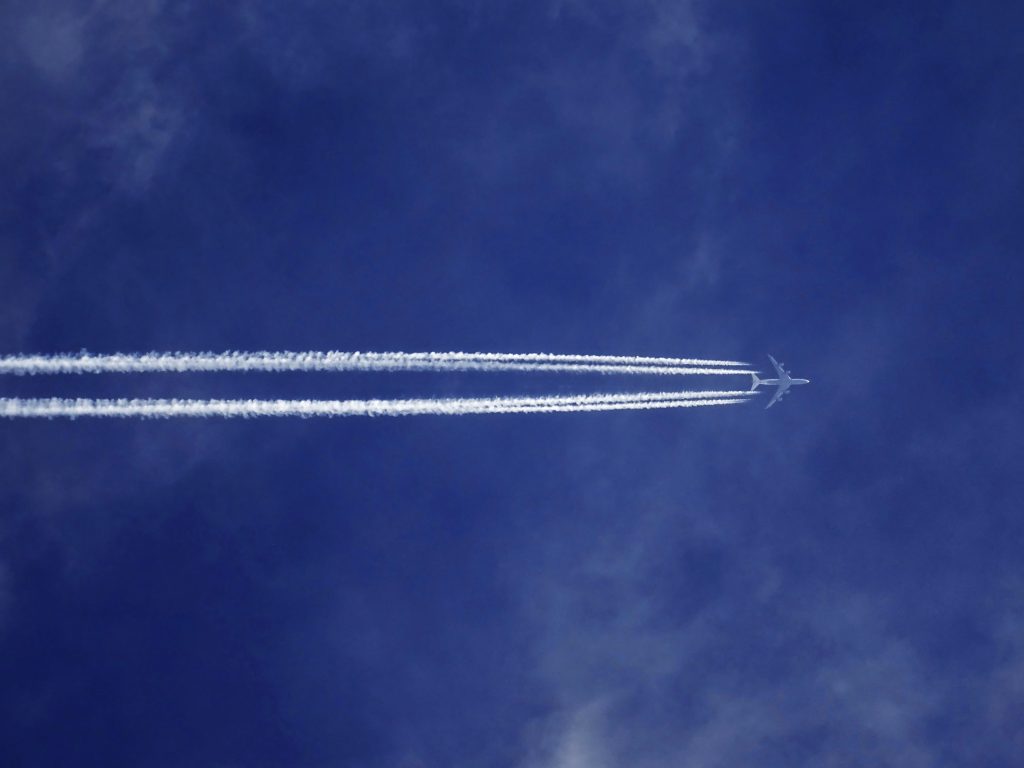 A stock image of a blue sky with a plane flying through it