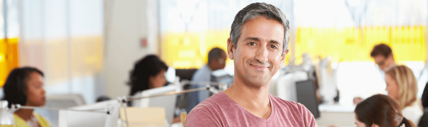 A person wearing a pink t-shirt standing in an open office